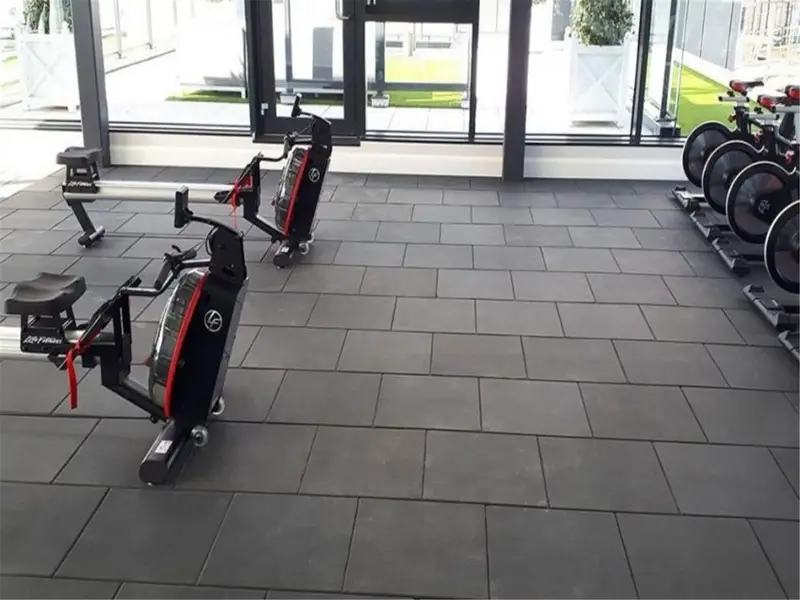 Gri karo kauçuk zemin kaplı fitness salonu ve kardiyo ekipmanları